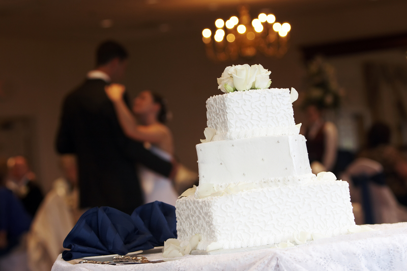 bride-and-groom-with-wedding-cake-615670290