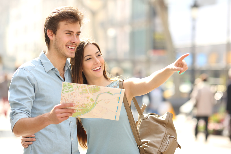 couple-of-tourists-consulting-a-city-guide-searching-locations-36919273965