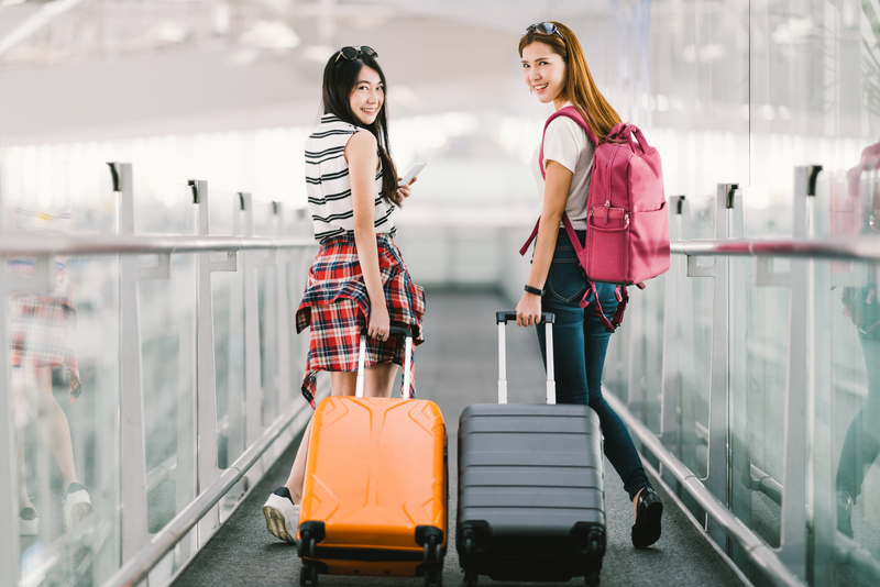 two-happy-asian-girls-traveling-abroad-together-carrying-suitcase-luggage-in-airport-air-travel-or-holiday-vacation-concept-064166447635
